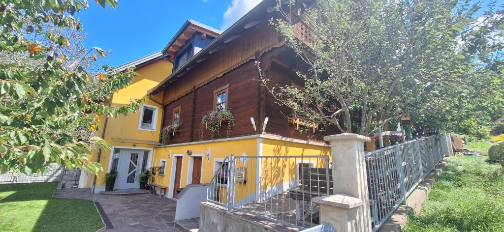 a yellow house with a fence in front of it at Ferienwohnung WIEKI in Puchreit