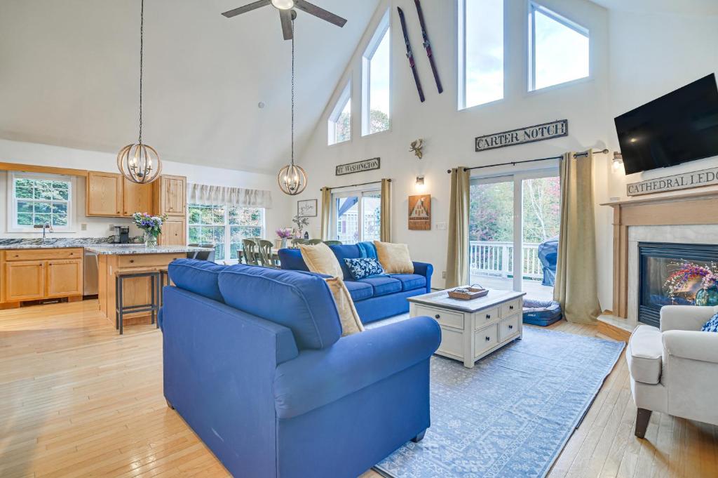 a living room with blue furniture and a fireplace at Pet-Friendly Home with Hot Tub Near Cranmore! in Conway