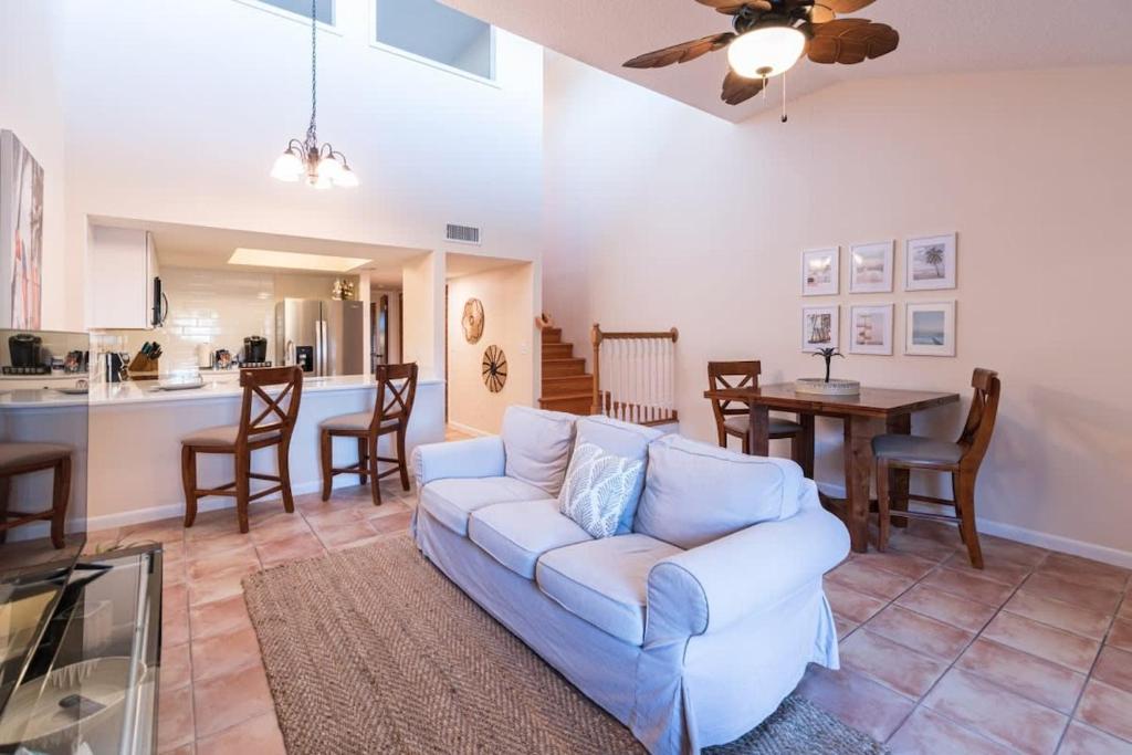 een woonkamer met een bank en een tafel bij Beach Townhome Steps from Downtown Cocoa Beach in Cocoa Beach