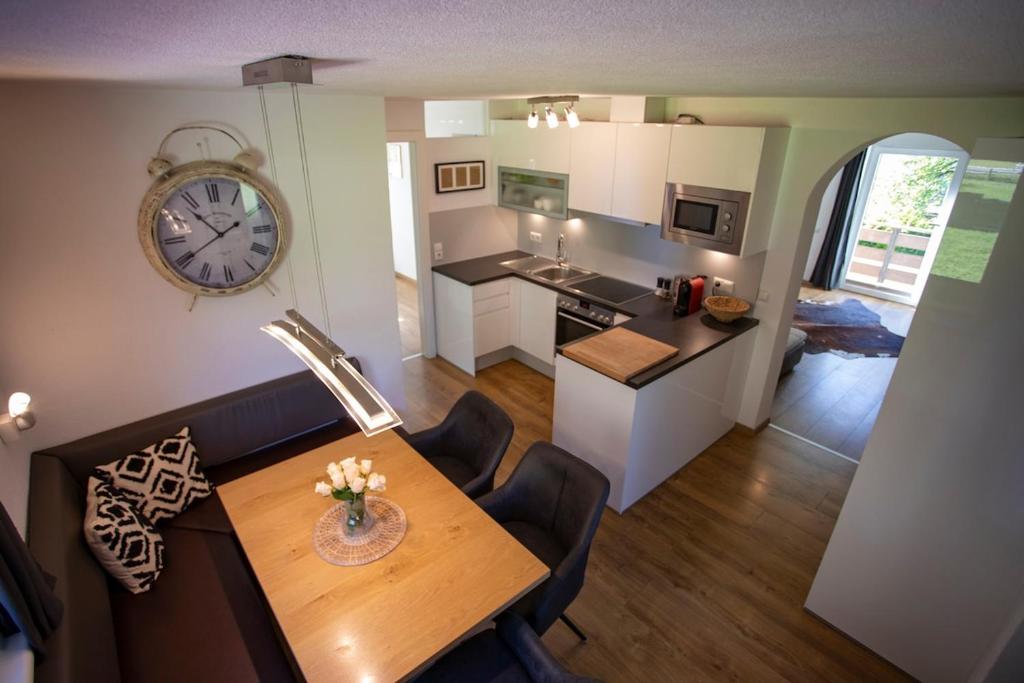 a kitchen and dining room with a table and a clock at Apartment Silbertanne in Pettnau