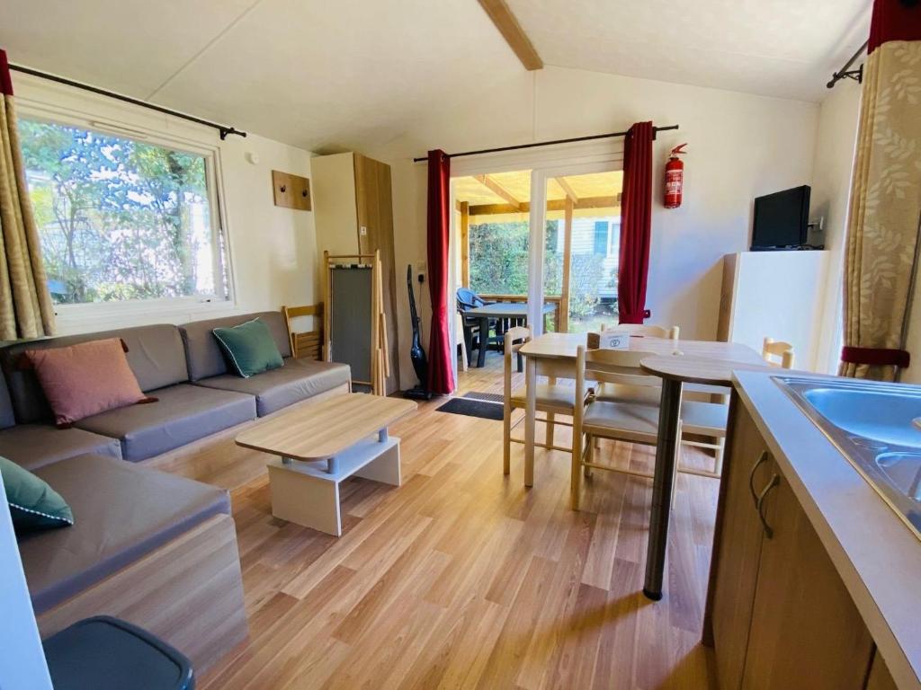 a living room with a couch and a table at Carnac - Mobil Home - 5 pers - 2 ch - Camping Moulin de Kermaux 4* - Piscine in Carnac