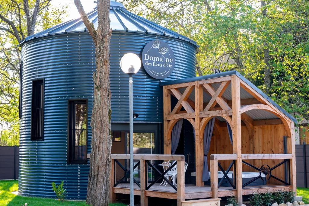 een blauw tiny house met een houten veranda bij Le Silo du Domaine des Ecus d'Or in Veuvey-sur-Ouche