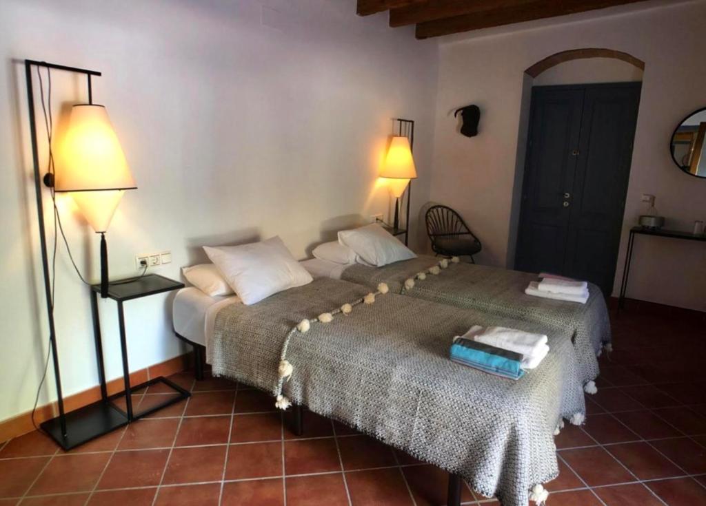 a bedroom with a bed with two lamps on it at Cortijo Bablou in Arcos de la Frontera