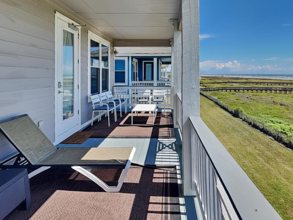 a porch with chairs and tables on a house at So Serene in Galveston