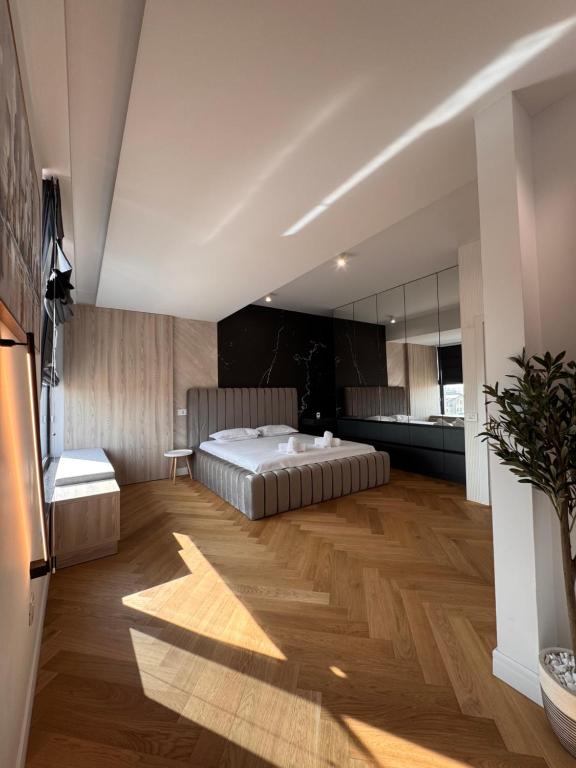 a large bedroom with a bed and a kitchen at Sky View Penthouse in Craiova
