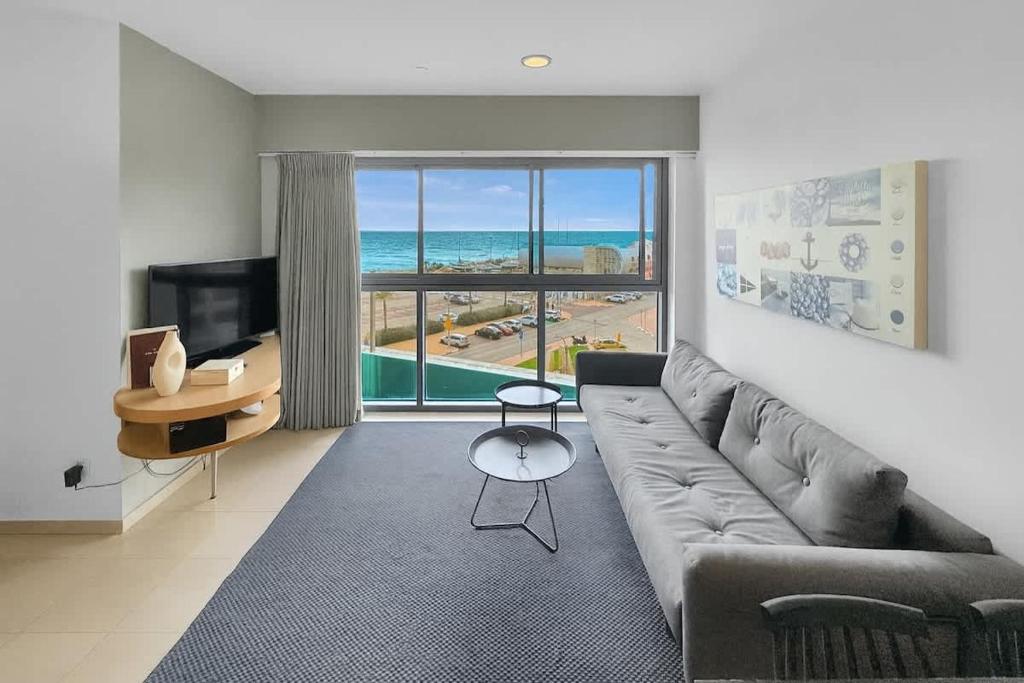 a living room with a couch and a view of the ocean at Okeanos Sea Loft in Herzliya B