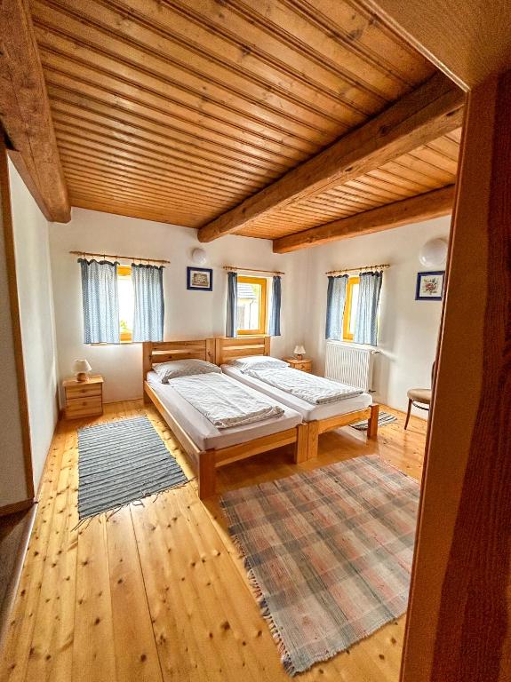 a bedroom with a large bed and a wooden ceiling at Penzion U Cempu in Kunratice