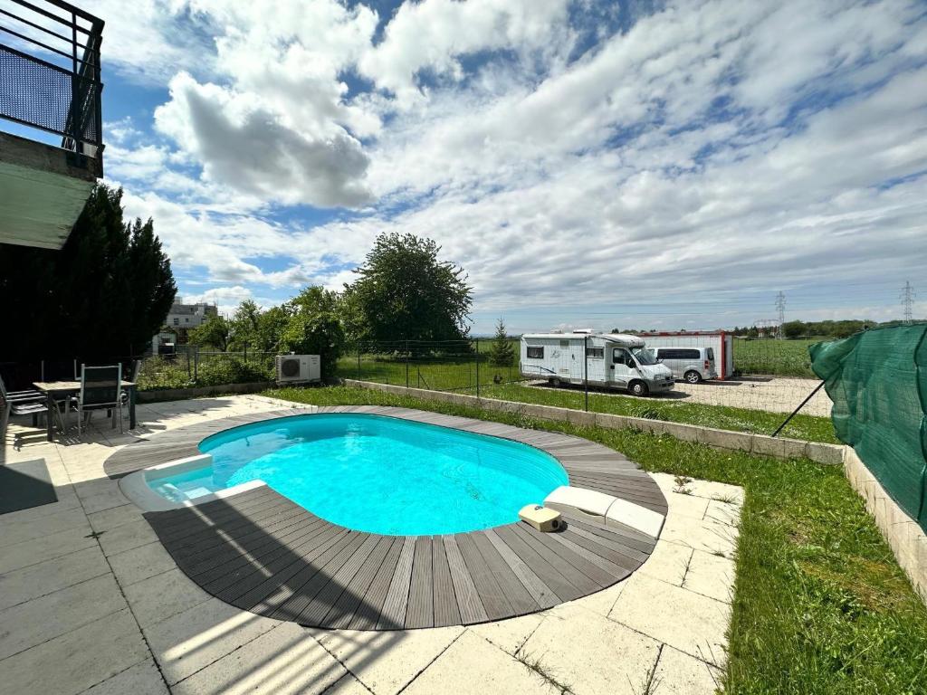 a swimming pool in a yard with a rv in the background at Résidence Foch in Trois-Moulins