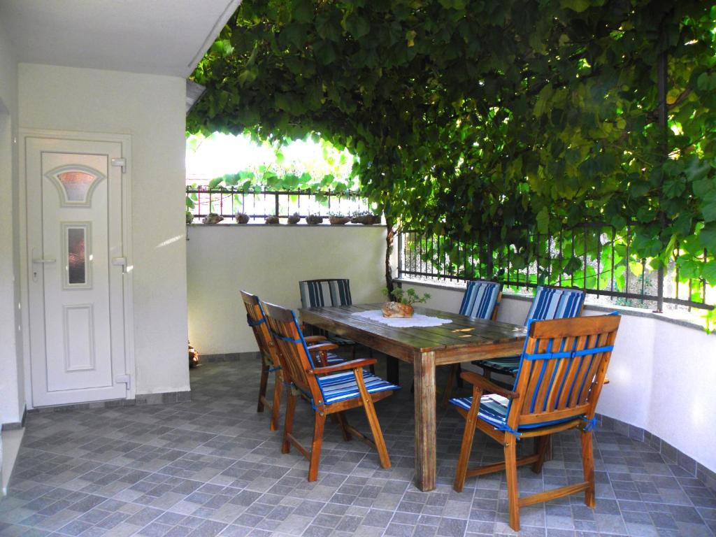 een houten tafel en stoelen op een patio bij Holiday Home Ruda in Vinišće