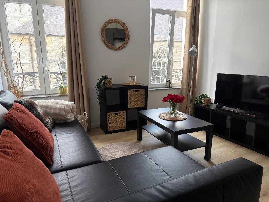 a living room with a couch and a table at Bright apartment in the heart of Chimay, 40 m² with view in Chimay