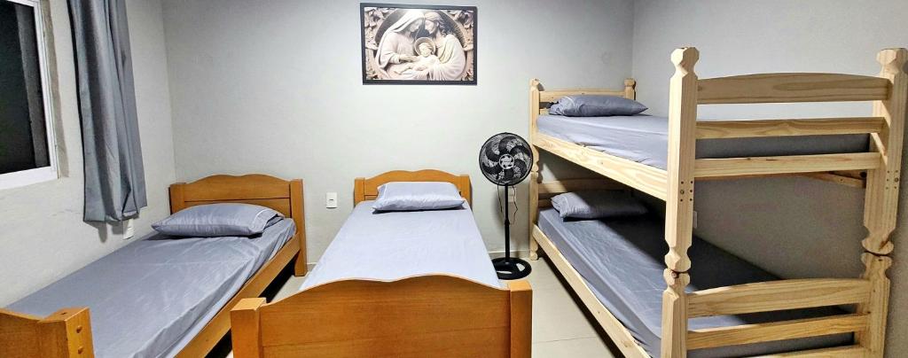 a room with two bunk beds and a room with another bed at Aliança da Fé in Cachoeira Paulista