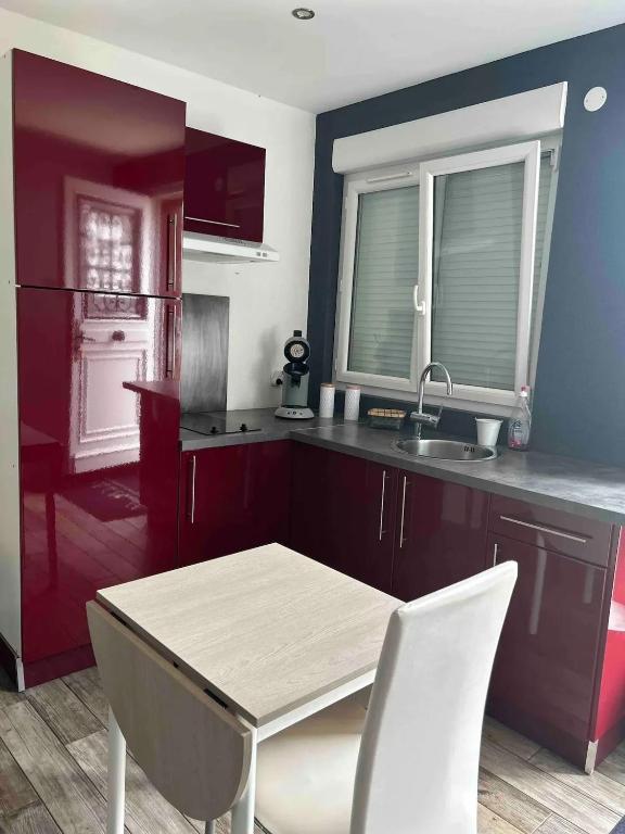 a kitchen with a table and chairs and a sink at Charmant studio près de Sancheville - 27 m² - 2 pers in Bercis