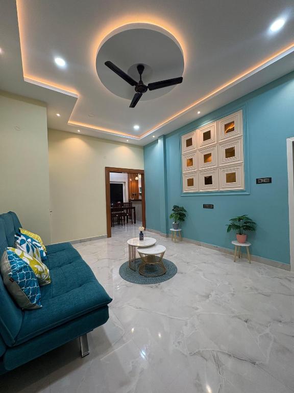 a living room with a ceiling fan and a couch at Rooftop Grove Zenith in Guwahati