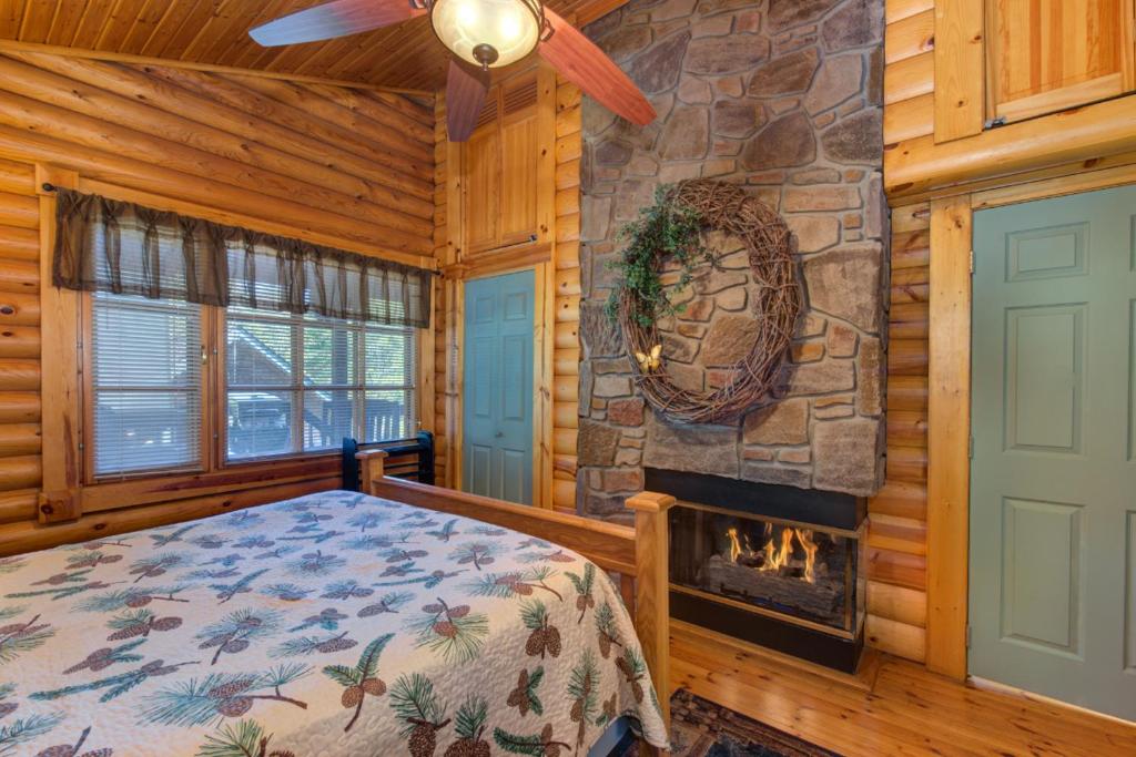 a bedroom with a fireplace in a log cabin at Unforgettable Dreams By Avada Properties in Catlettsburg
