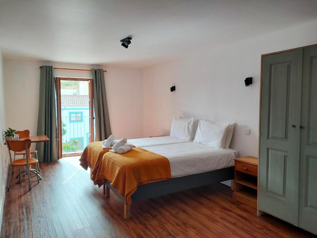 a bedroom with a large bed and a window at Casa Fidal in Bordeira