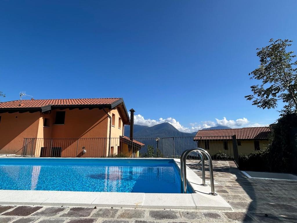 a swimming pool in front of a house at Lily apartment, Stunning Lake View in Germasino