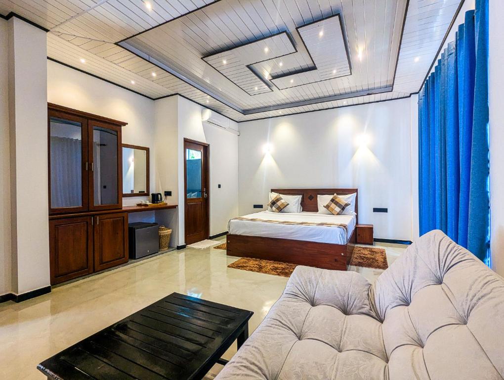 ein Wohnzimmer mit einem Bett und einer Couch in der Unterkunft Arice Eco Villa and Restaurant Unawatuna in Galle