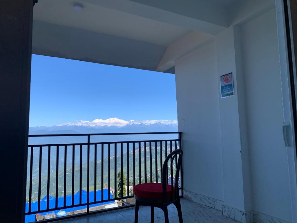 a balcony with a chair and a view of the ocean at Begonia Homestay Darjeeling in Darjeeling