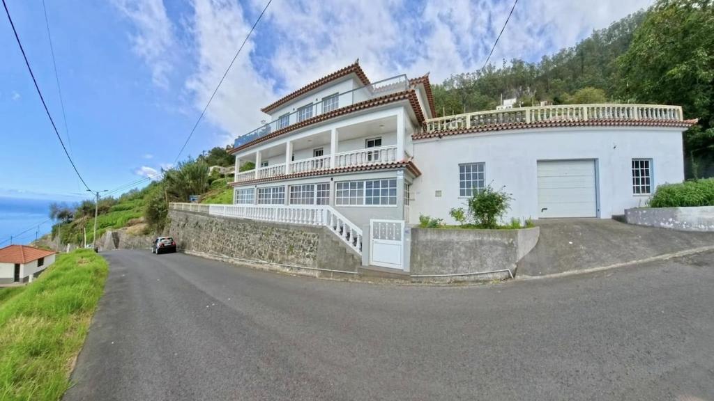 une grande maison blanche à flanc de colline dans l'établissement Casa Borboleta, à Arco da Calheta