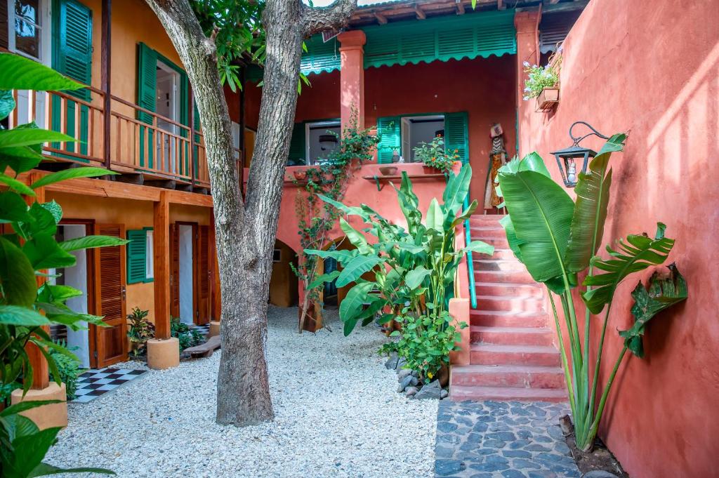 a red building with stairs and plants in front of it at Maison Crespin in Dakar