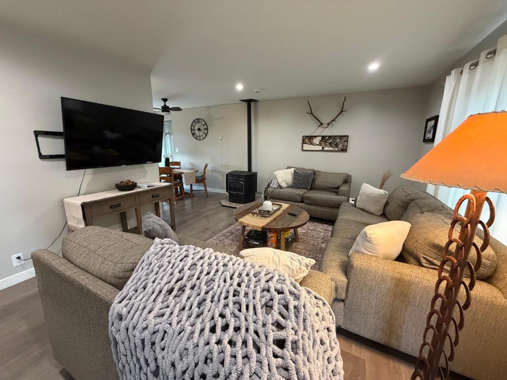 a living room with two couches and a flat screen tv at The Cowboy Corral in Casper