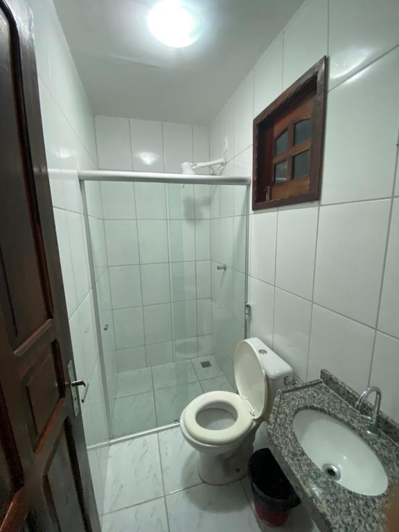 a bathroom with a shower and a toilet and a sink at Pousada Linhares in Canoa Quebrada