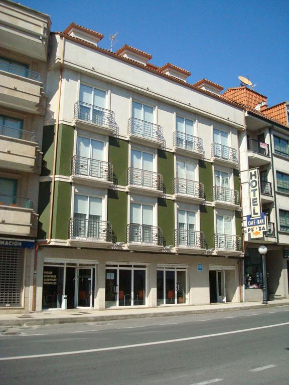 a green and white building on the side of a street at Hotel Plaza in Portonovo