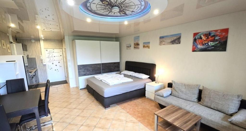 een slaapkamer met een bed, een bank en een klok bij Leuchtturm in Schönberg