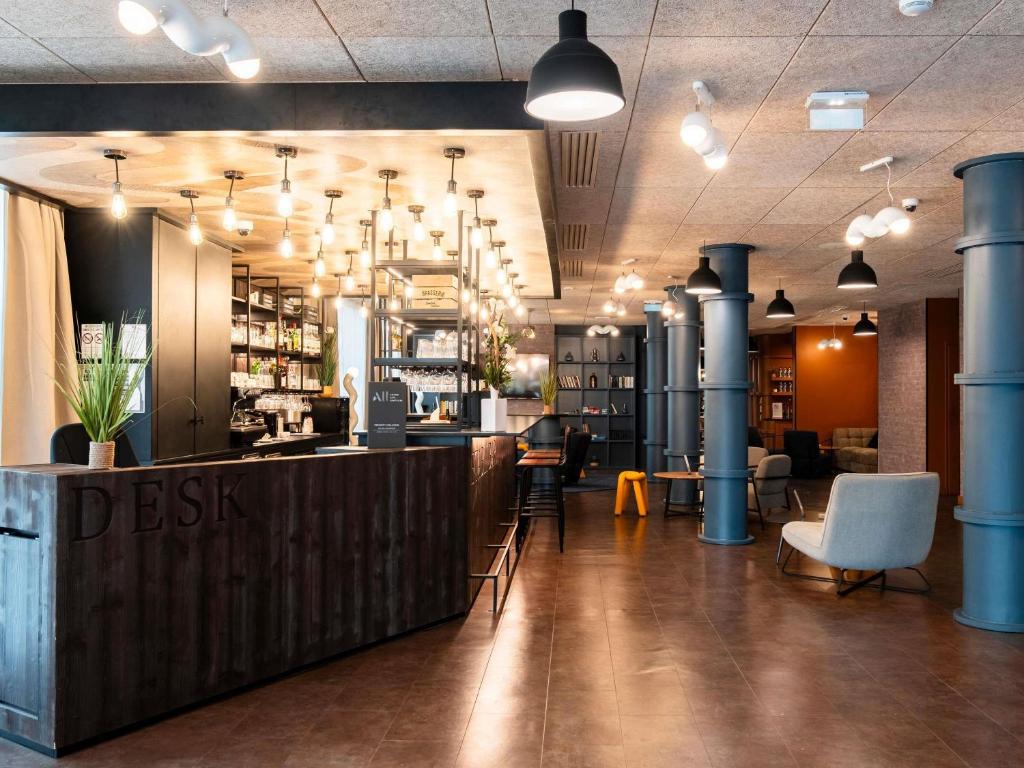 a restaurant with a bar with chairs and tables at Ibis Styles Lyon Villeurbanne Parc de la Tête d'Or in Villeurbanne