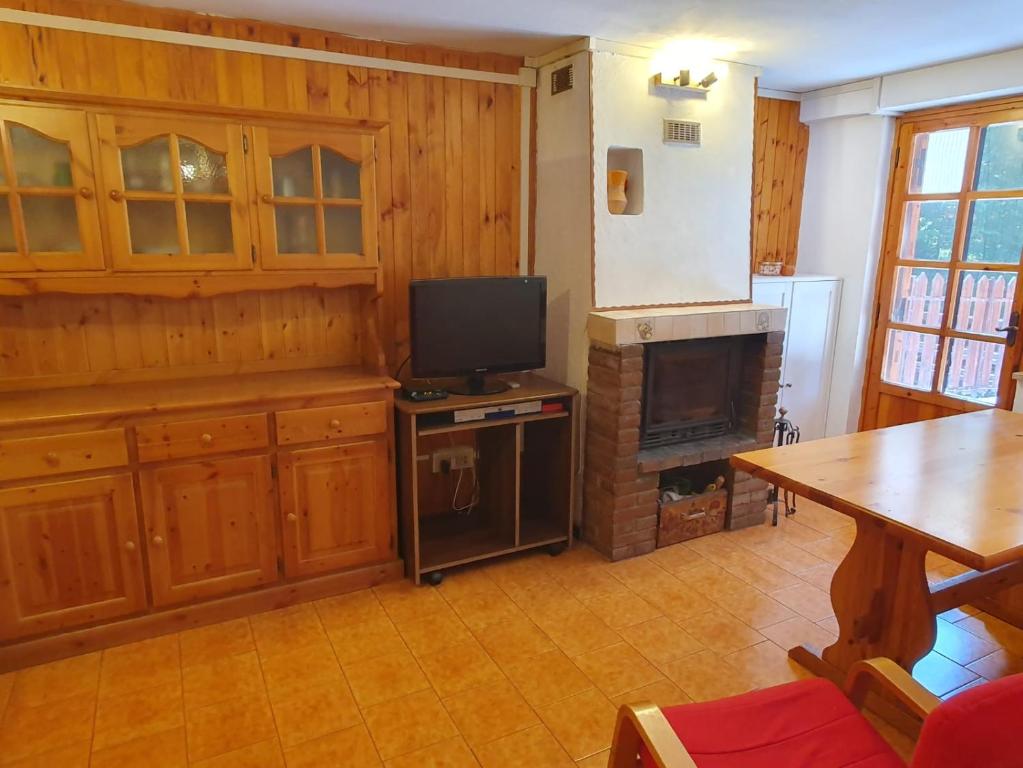 sala de estar con TV y chimenea en Casa - La Faggeta, en Subiaco