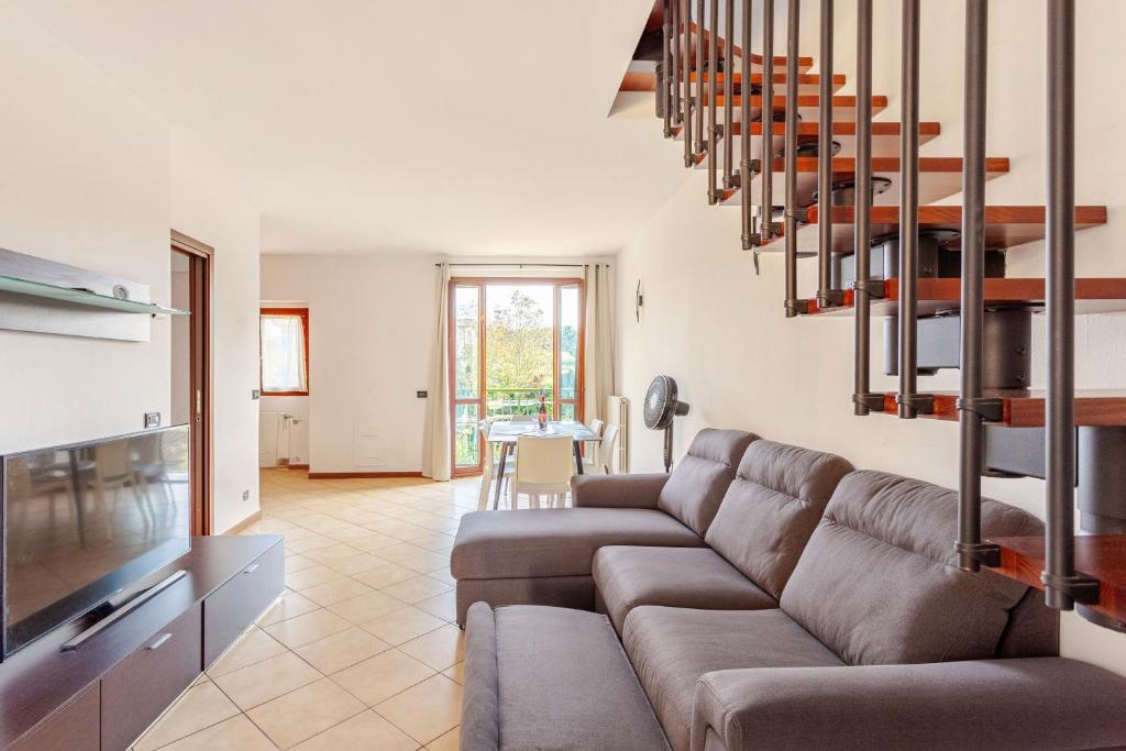 a living room with a couch and a staircase at Lago di Monate Apartment in Osmate Lentate