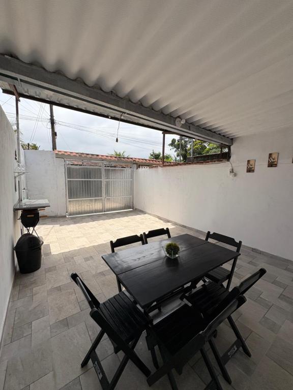 eine Terrasse mit einem Tisch und Stühlen auf einer Terrasse in der Unterkunft Casa em Angra dos Reis, no parque mambucaba in Angra dos Reis
