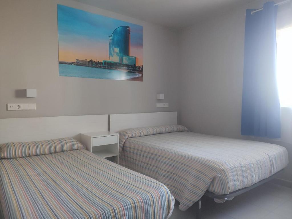 a room with two beds and a picture on the wall at Hotel Blauet by Bossh! Hotels in El Prat de Llobregat