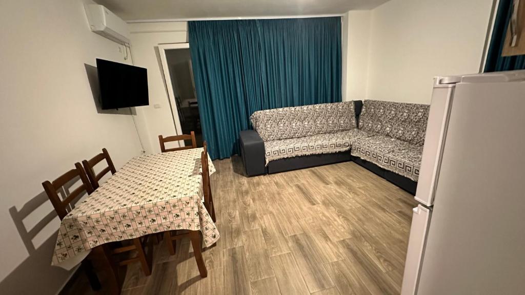 a living room with a couch and a table and chairs at Apartamente me qera tale plazh lezhë in Lezhë
