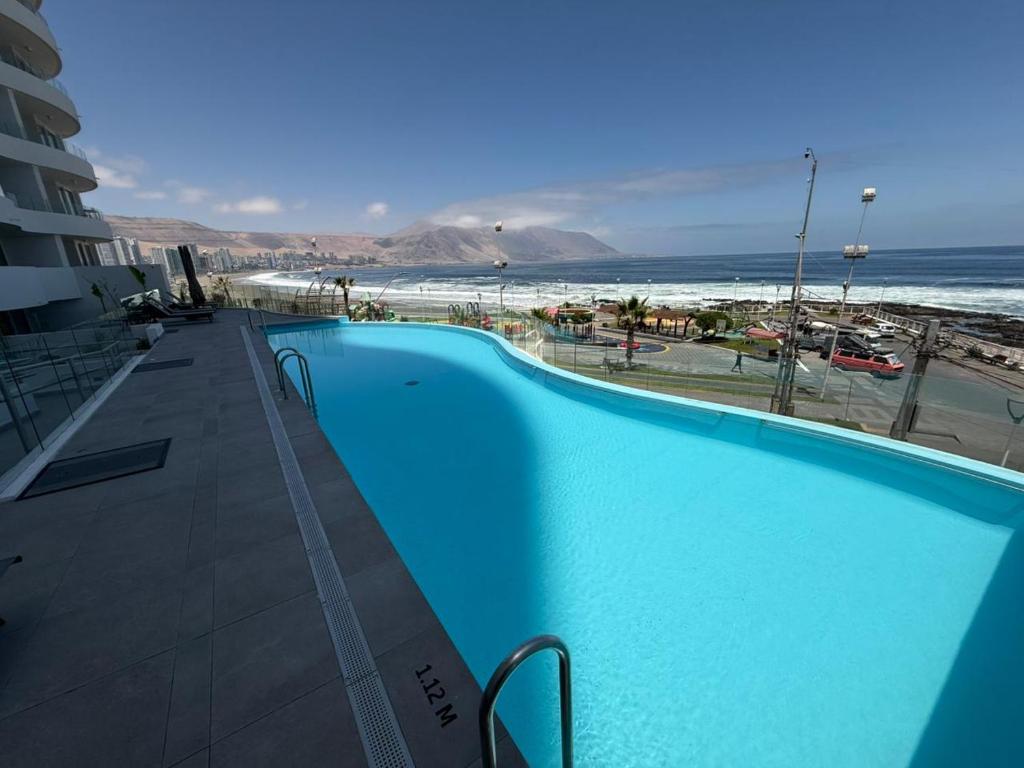 a large blue swimming pool next to a beach at Frente a Playa Brava, Cerca Cavancha, WiFi in Iquique
