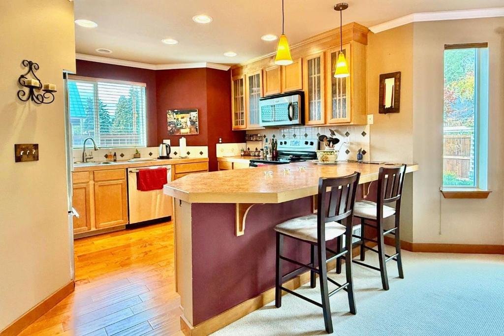 una cucina con una grande isola con sgabelli da bar di Cle Elum Furnished Condo in Town a Cle Elum