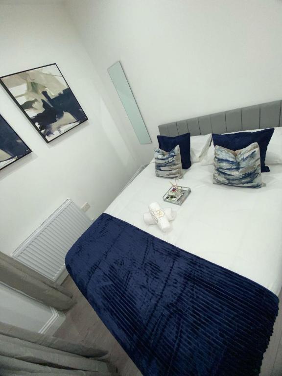 a bed with a blue blanket and pillows on it at Luxe Apartment in Croydon