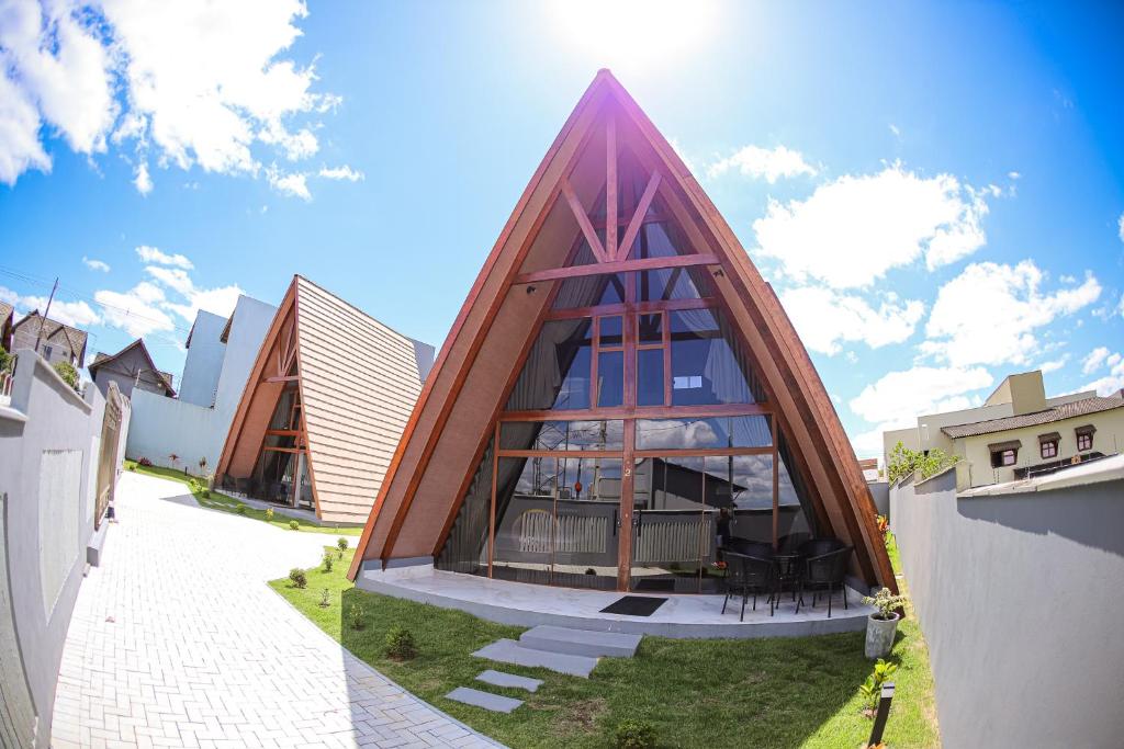 a house with a triangular roof on a yard at Cabanas Vovó Tezinha in Bananeiras
