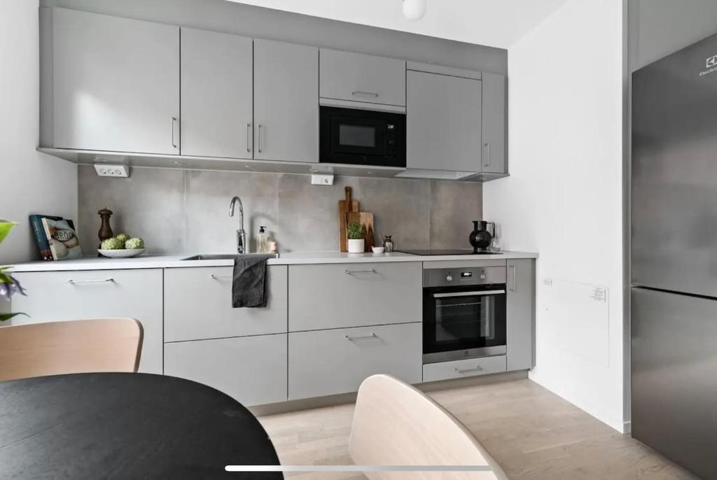 ストックホルムにあるBright and modern studio with a great locationの白いキャビネットと黒いテーブル付きのキッチン