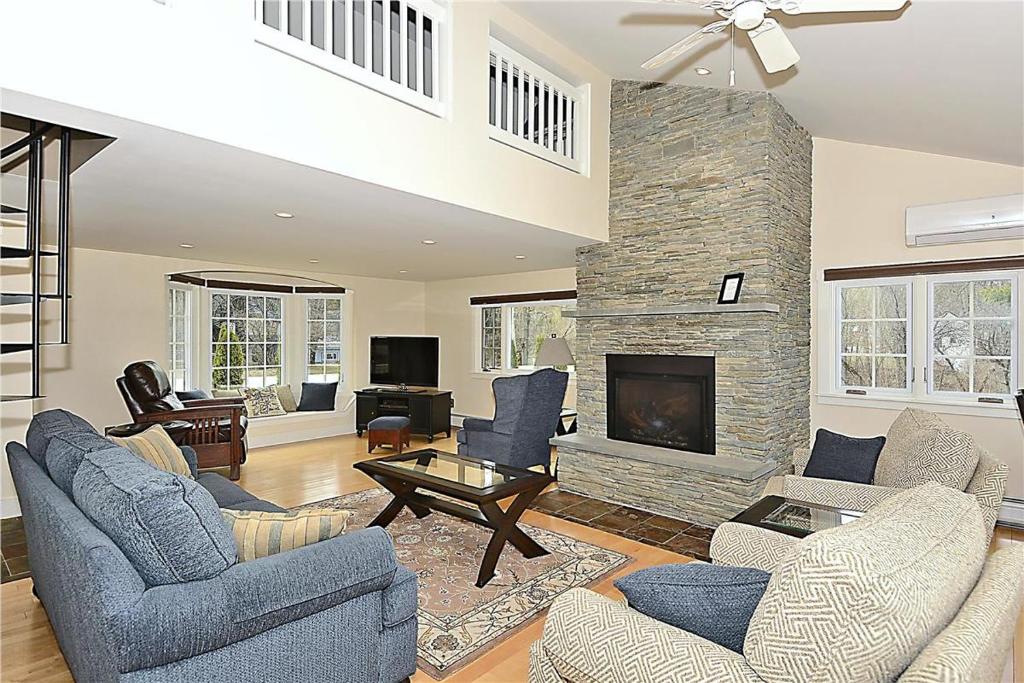 a living room with couches and a stone fireplace at Pucker Street in Stowe