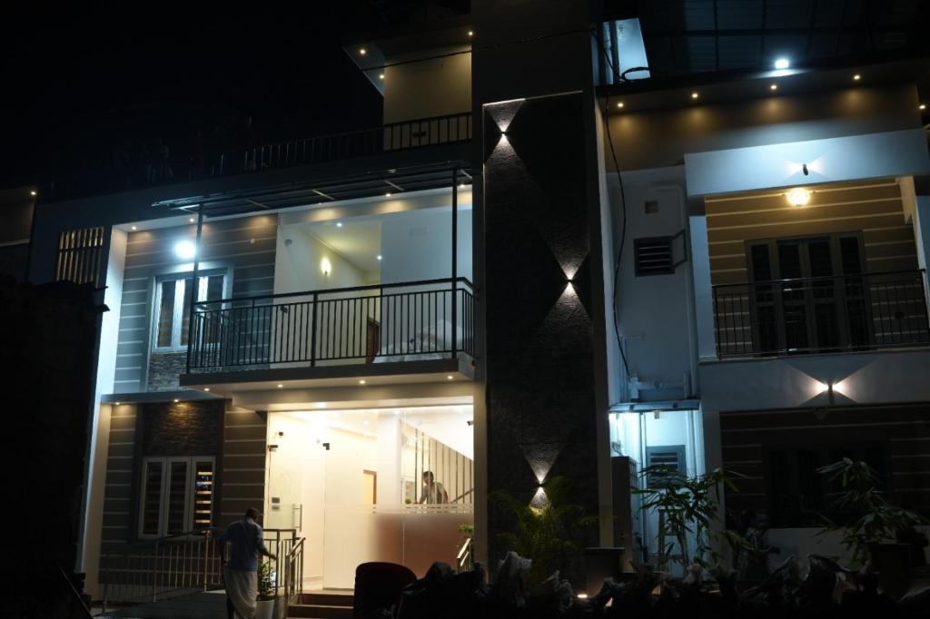 a man standing in front of a building at night at Joen homes apartment in Alwaye