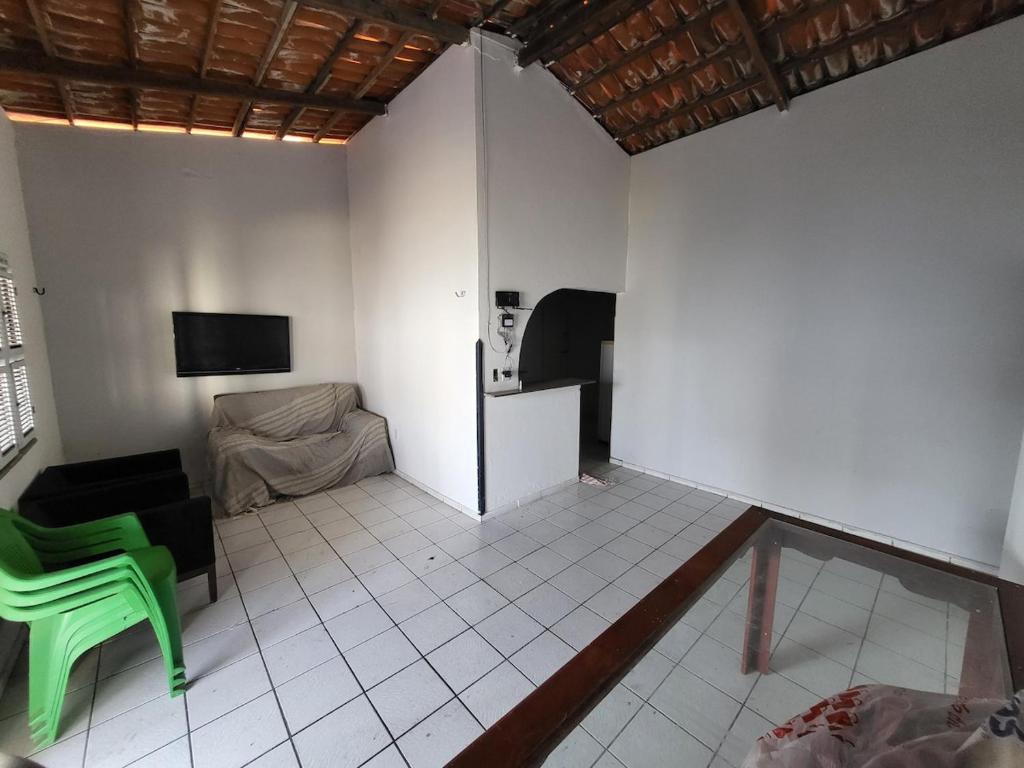 a living room with a green chair and a couch at Casa grande Pacheco in Caucaia