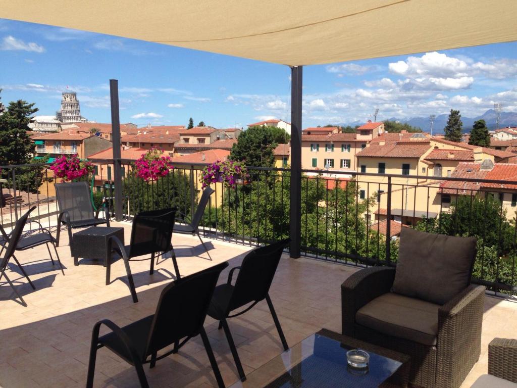 a patio with chairs and tables and a view of the city at Hotel Di Stefano in Pisa