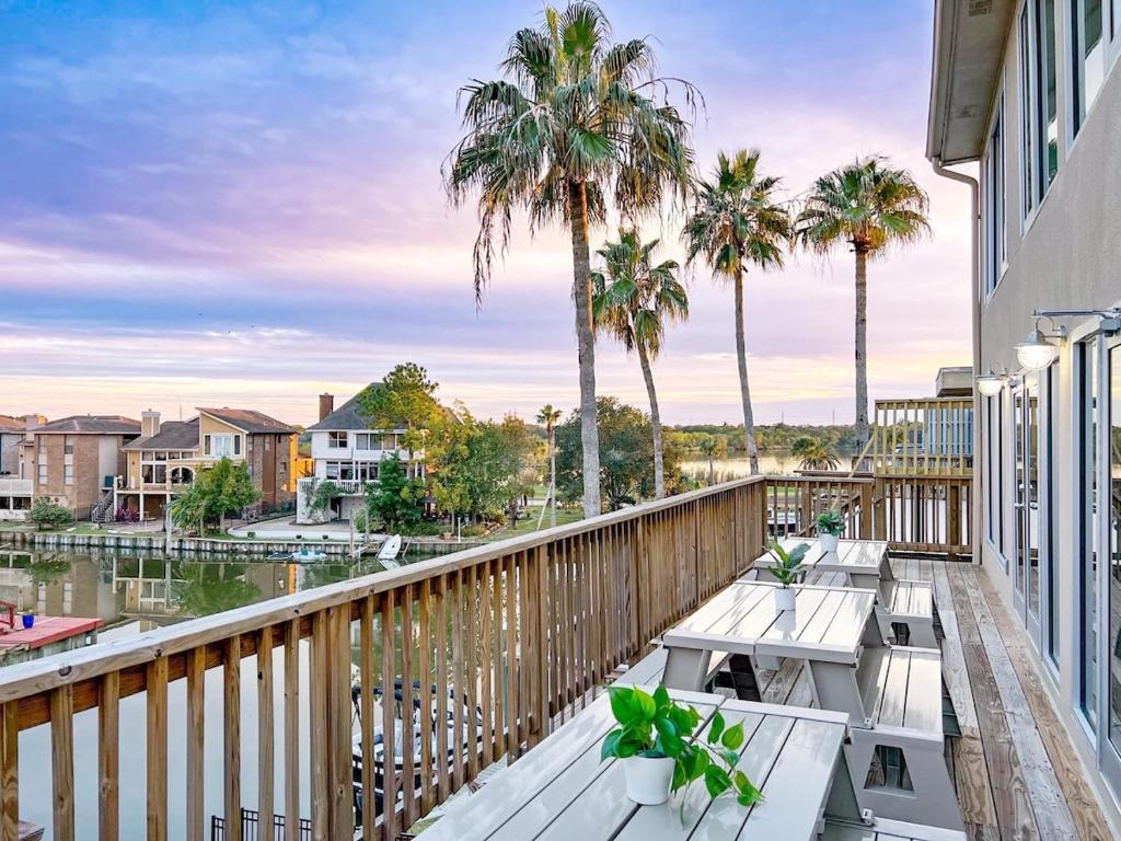 Un balcón con mesas y palmeras y agua. en Waterfront, en Houston