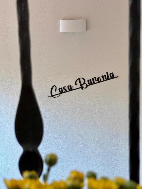 a sign on a wall with a plate of food at Casa Baronia in Assemini