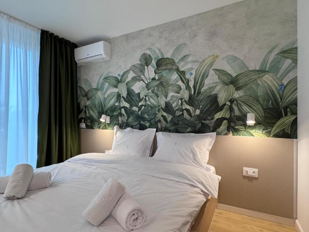 een slaapkamer met een groot bed met een plantenmuurschildering bij Hotel Bravo Iasi in Iaşi