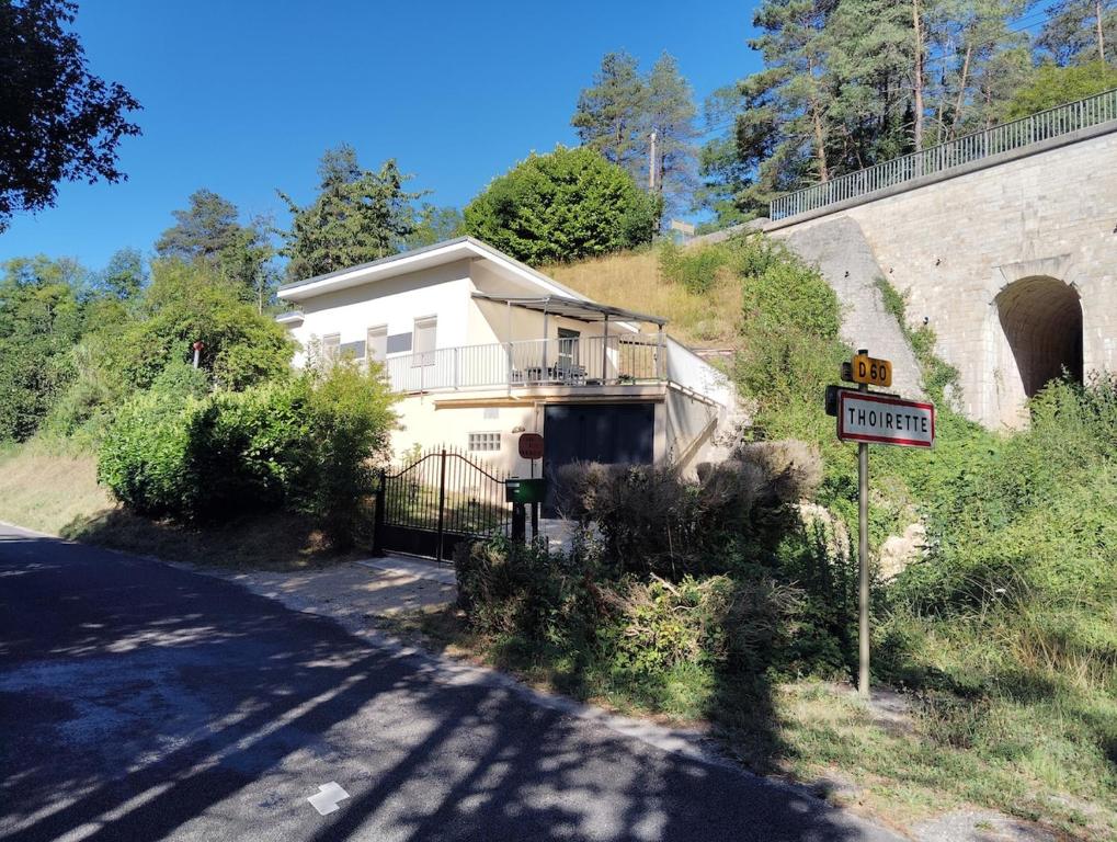 a house on the side of a road next to a tunnel at petite maison sans vis a vis in Thoirette