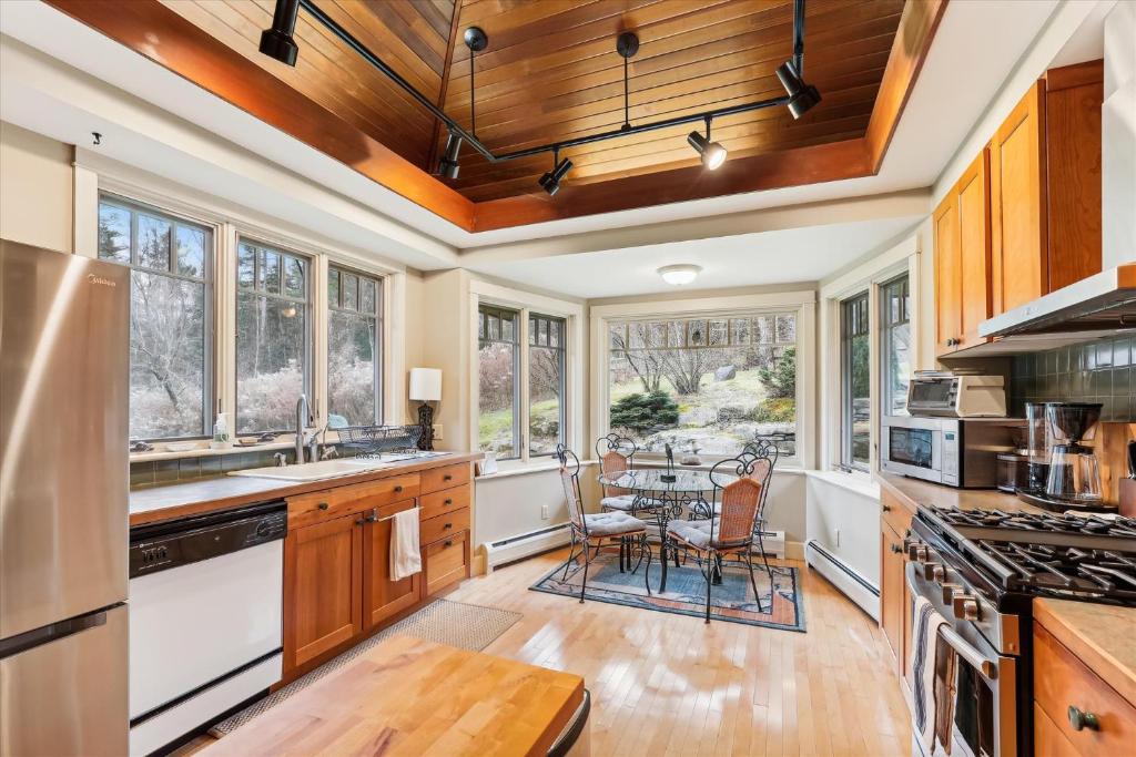 a kitchen with wooden cabinets and a table with chairs at Raven's Nest in Stowe