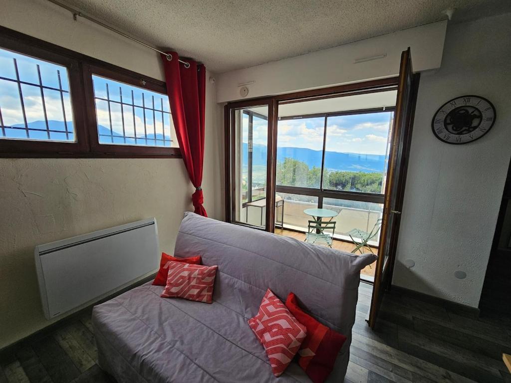 ein Wohnzimmer mit Couch und großem Fenster in der Unterkunft Cozy 1-room apartment with veranda and parking in Font-Romeu