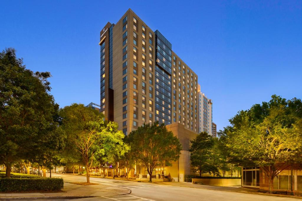 a tall building on a city street with trees at Renaissance Atlanta Midtown Hotel in Atlanta